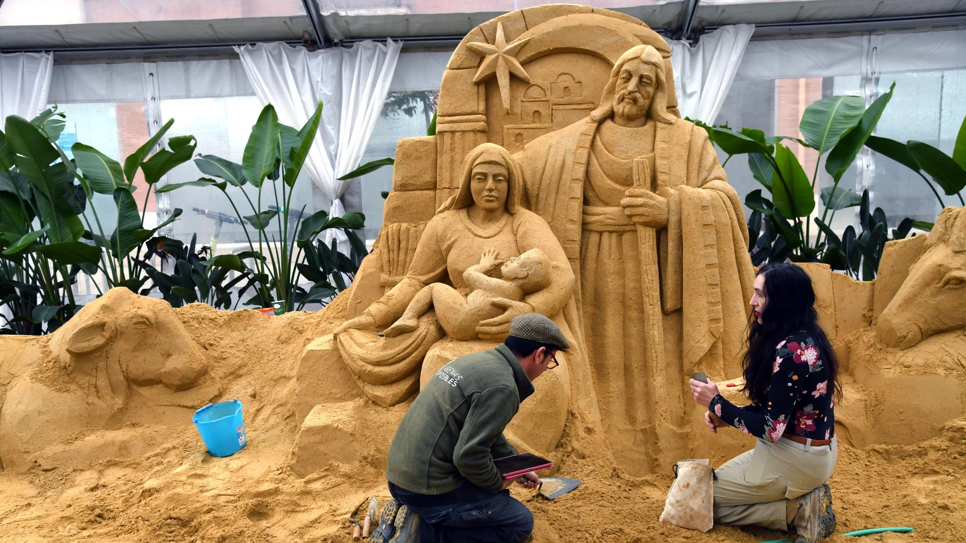Los escultores Monserrat Cuesta y Sergi Ramírez elaboran el belén de arena en la Plaza de la Paja