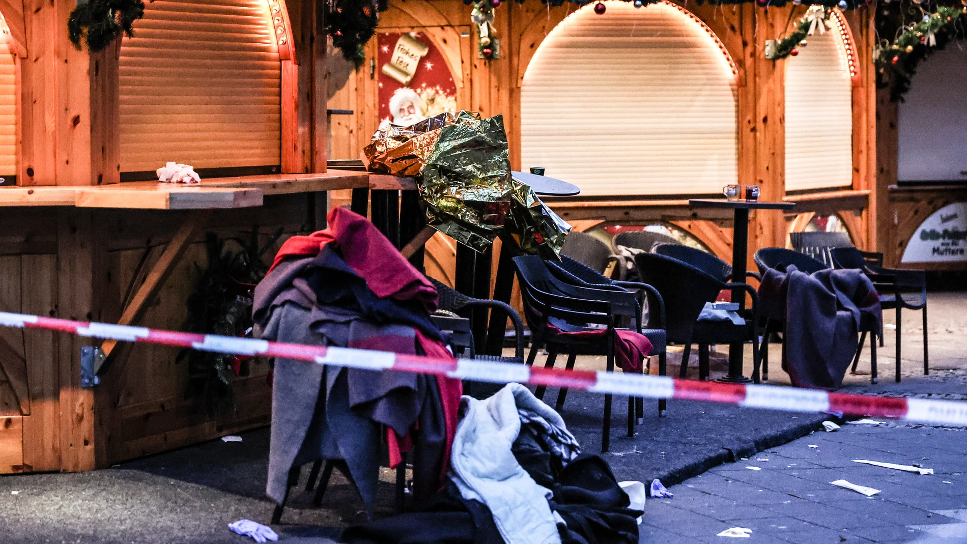 FOTODELDÍA MAGDEBURGO (ALEMANIA), 21/12/2024.- Prendas de ropa apiladas en sillas se ven detrás de un cordón policial después de un atropello en un mercadillo de Navidad en Magdeburgo, en el este de Alemania, en un atentado cometido aparentemente sin cómplices por un médico saudí que llevaba desde 2006 en el país centroeuropeo y que se encuentra detenido, según las autoridades regionales. EFE/ Filip Singer