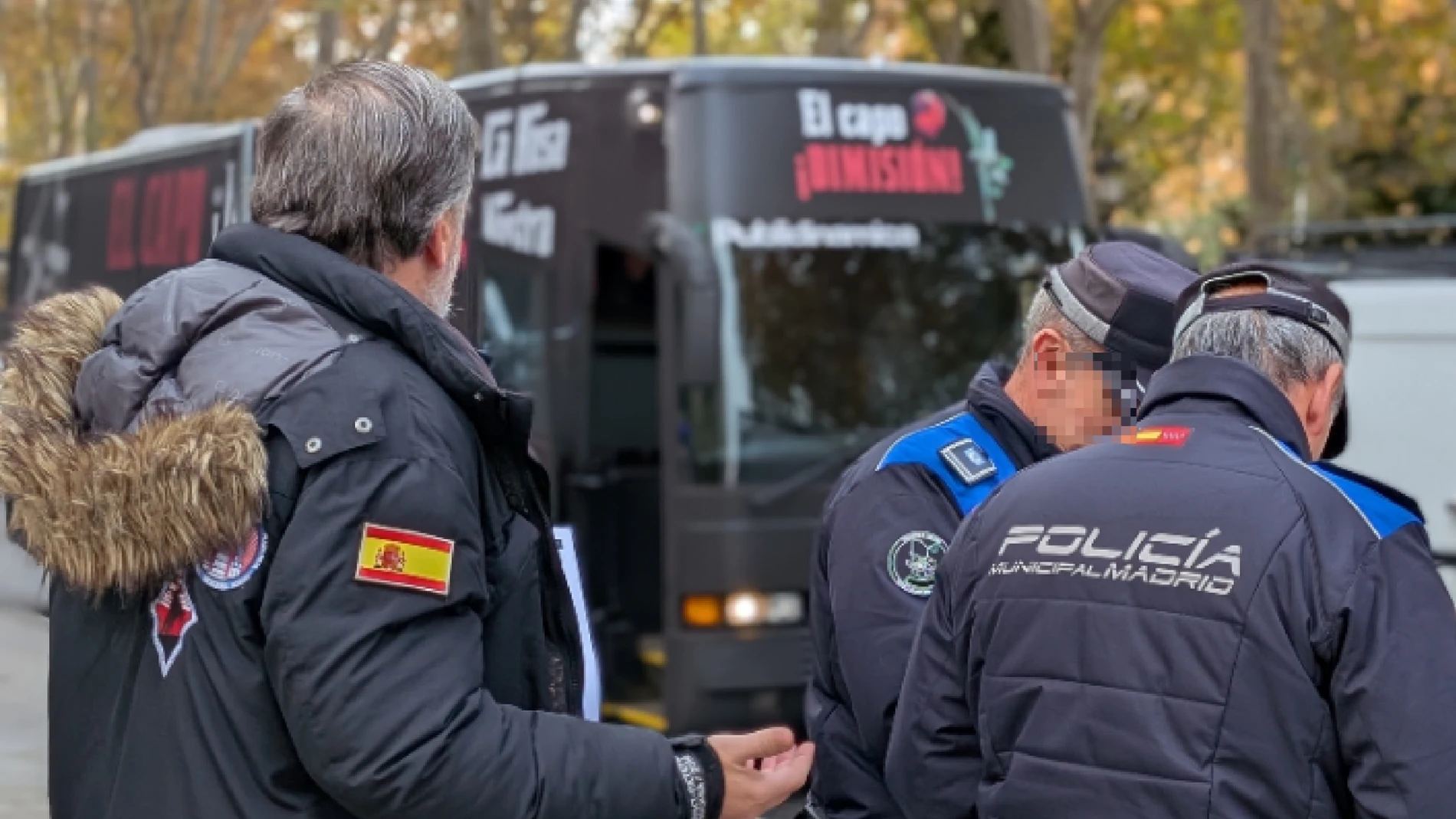 Agentes de la Policía Municipal, junto al presidente de Hazte Oír, Ignacio Arsuaga, y, de fondo, el autobús con el que piden la dimisión de Pedro Sánchez