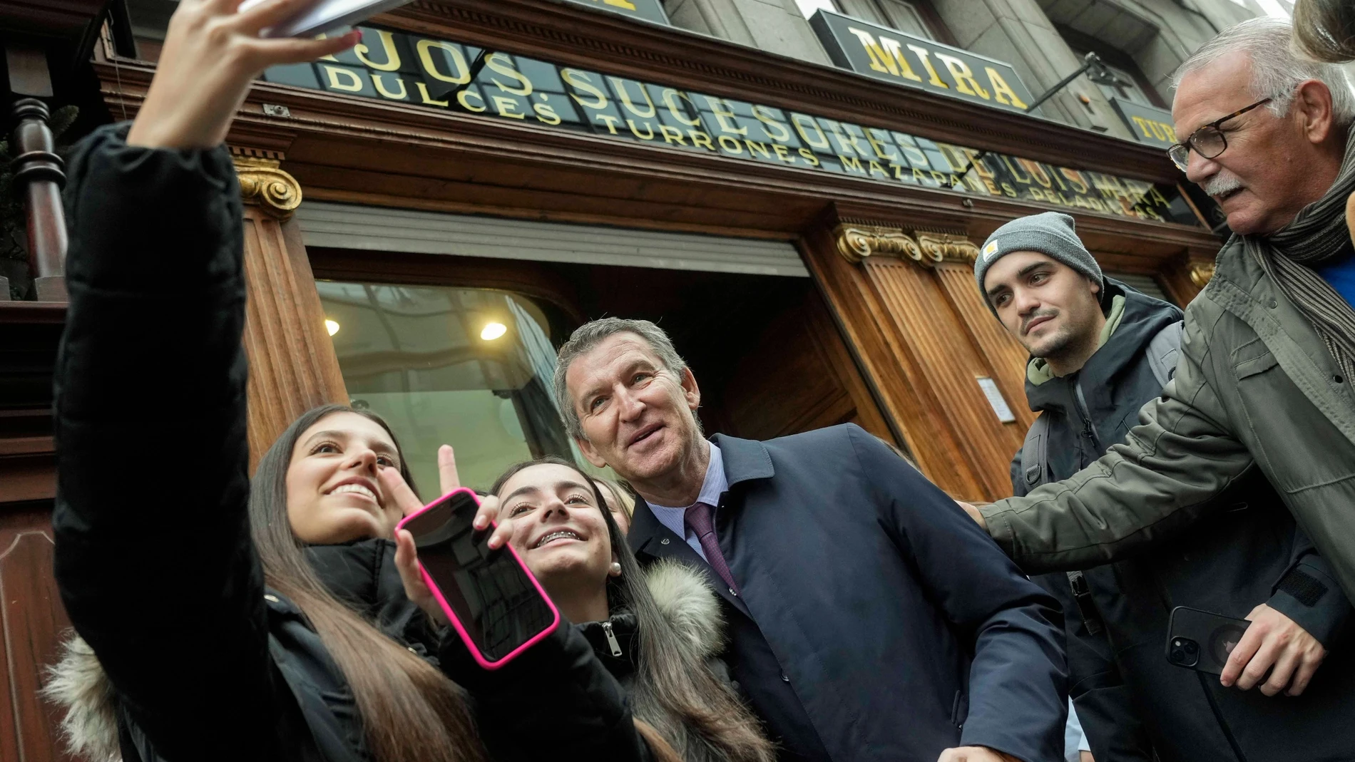 El líder del PP, Alberto Núñez Feijóo, a las puertas del comercio centenario de turrones artesanos, Casa Mira.