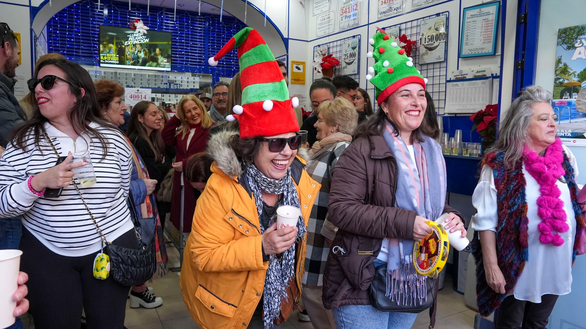 CHIPIONA (CÁDIZ), 22/12/2024.- Premiados y vecinos celebran este domingo el segundo premio del sorteo extraordinario de la lotería de Navidad caído en la administración número 1 de Chipiona (Cádiz). EFE/Román Ríos