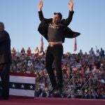 Elon Musk jumps on the stage as Republican presidential nominee former President Donald Trump speaks at a campaign rally at the Butler Farm Show, Saturday, Oct. 5, 2024, in Butler, Pa. 