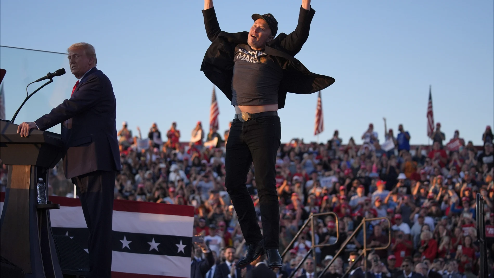 Elon Musk jumps on the stage as Republican presidential nominee former President Donald Trump speaks at a campaign rally at the Butler Farm Show, Saturday, Oct. 5, 2024, in Butler, Pa.