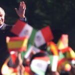 King Juan Carlos of Spain looks at children waving Mexican and Spanish flags during an official reception at the Campo Marte in Mexico City, Monday, Nov. 18, 2002. 
