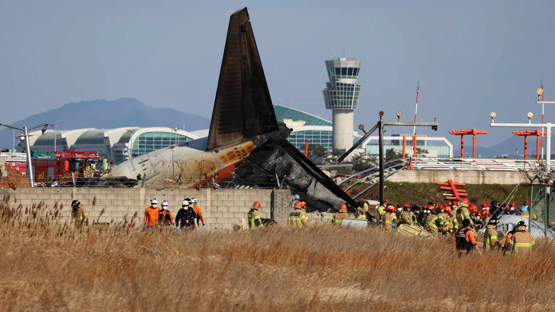 Muan (Korea, Republic Of), 29/12/2024.- Firefighters carry out rescue operations at Muan International Airport in Muan, 288 kilometers southwest of Seoul, South Korea, 29 December 2024, after a passenger plane with 181 people aboard crashed. According to Yonhap New Agency, at least 28 people died after the Jeju Air passenger plane crashed during landing. The flight was inbound from Bangkok, Thailand. (Corea del Sur, Tailandia, Seúl) EFE/EPA/YONHAP SOUTH KOREA OUT