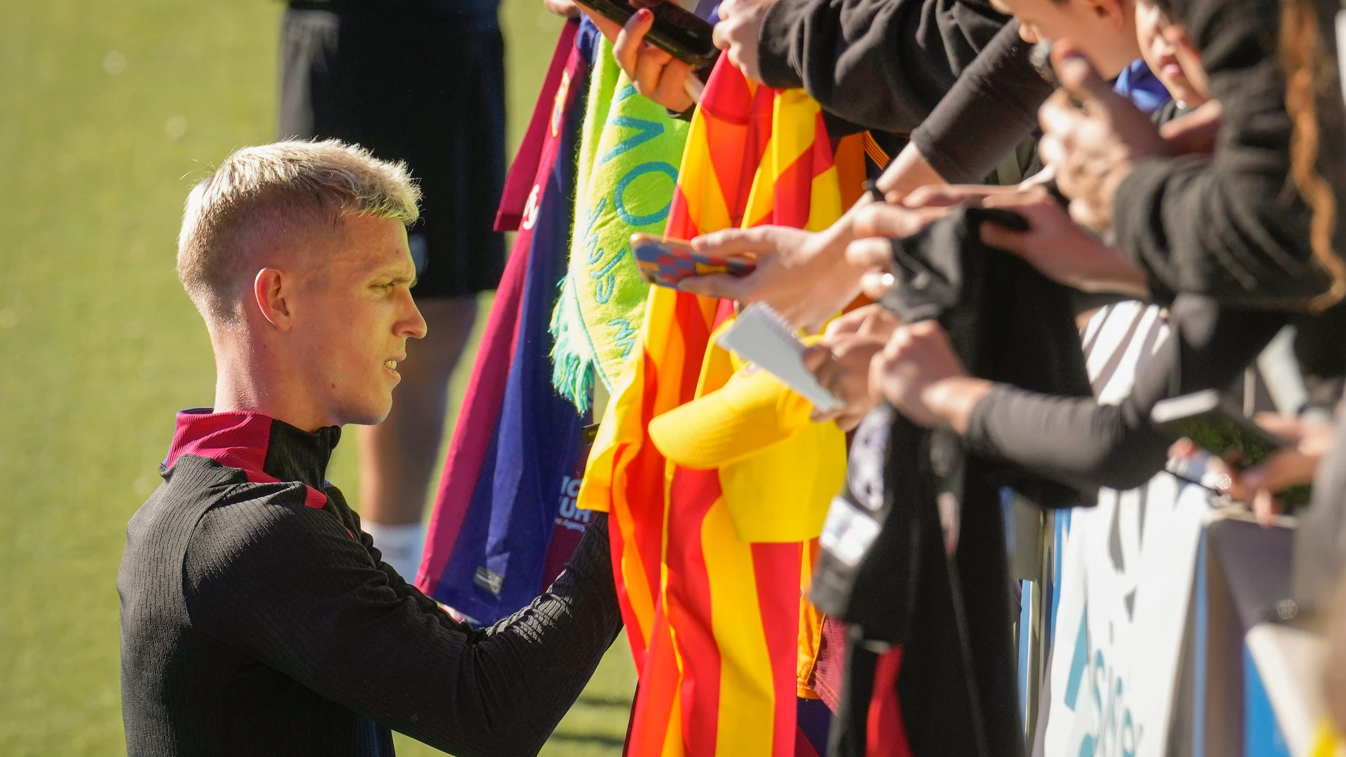 FOTODELDÍA SANT JOAN DESPÍ, 29/12/2024.- Dani Olmo (i) firma autñografos durante el entrenamiento del primer equipo del FC Barcelona que se ha celebrado este domingo en el estadio Johan Cruyff con las puertas abiertas al publico. EFE/ Enric Fontcuberta