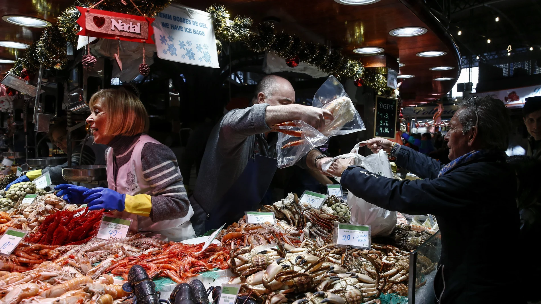 Aspecto del mercado de la Boquería de Barcelona, hoy lunes 23 de diciembre, cuando muchos esperan hasta última hora para hacer las compras para la cena de Nochebuena.