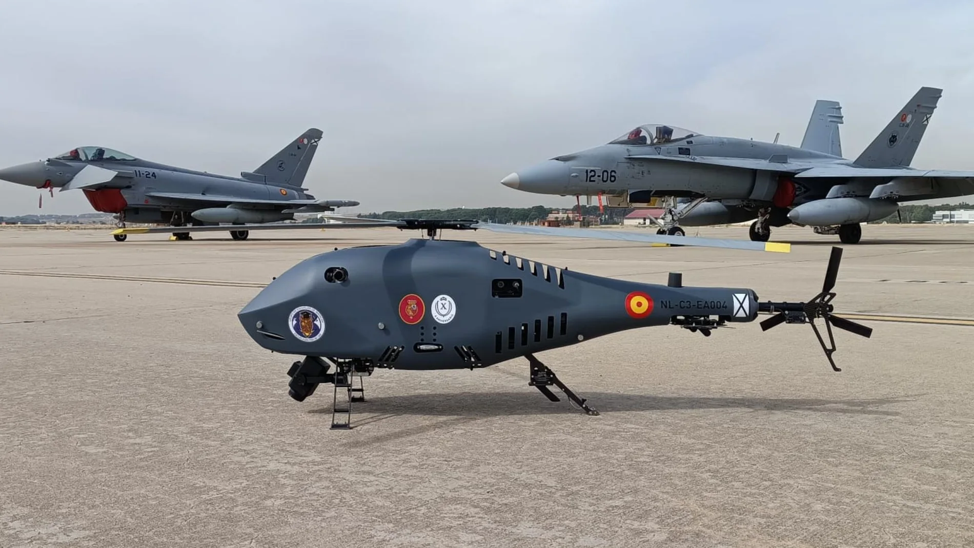 El helicóptero no tripulado español Alpha 900 con el logo del Ejército del Aire junto a un Eurofighter y un F-18