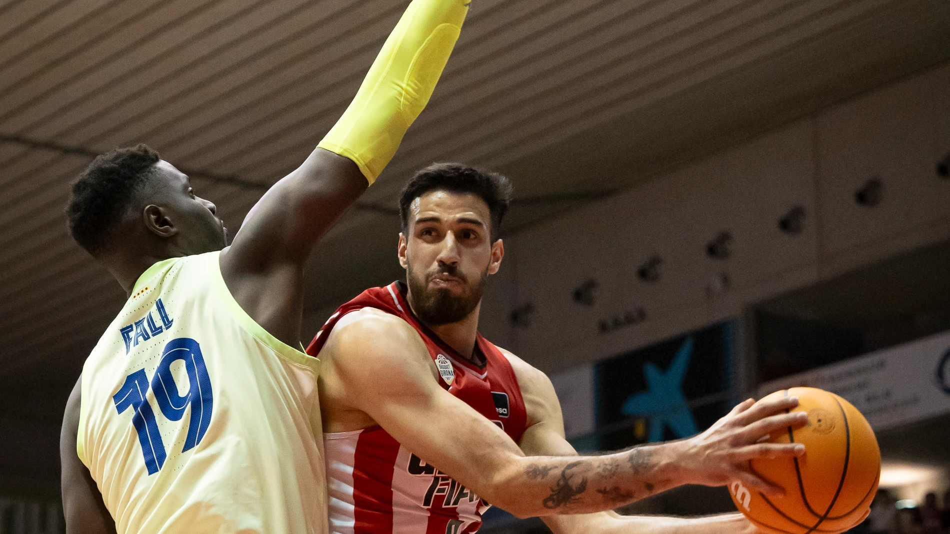 GIRONA, 07/01/2025.- El jugador del Girona Juan Fernández (d) entra a canasta ante Youssoupha Fall, del Barça, durante el partido de la Liga Endesa de baloncesto que Básquet Girona y Barcelona disputan este martes en el pabellón de Fontajau. EFE/David Borrat