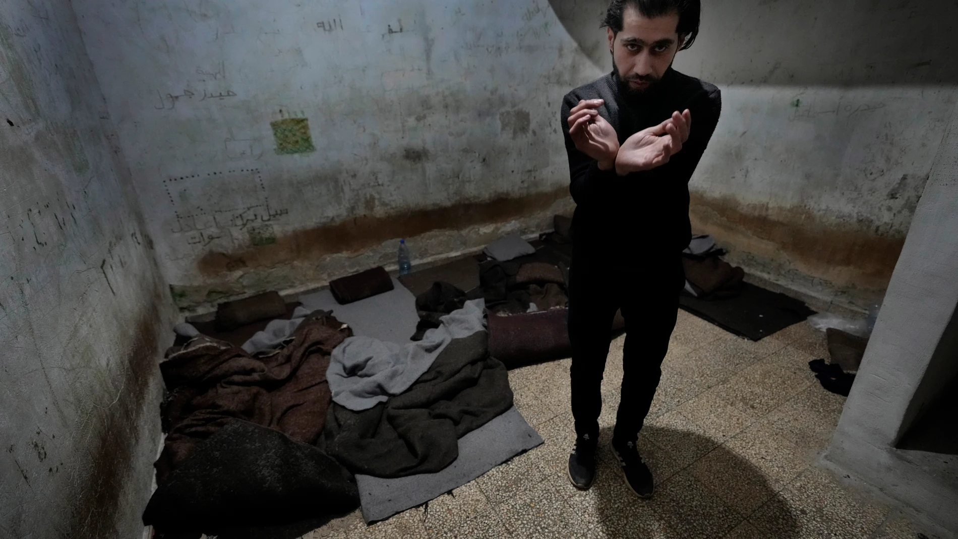 Abdullah Zahra demonstrates how he was tortured in a cell at Branch 215, a detention facility run by military intelligence during Bashar Assad's regime, in Damascus, Syria, on Tuesday, Dec. 17, 2024. (AP Photo/Hussein Malla)