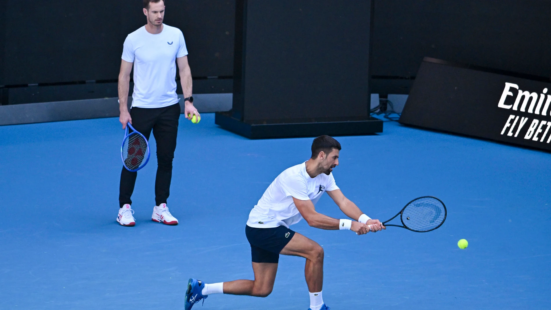 Novak Djokovic of Serbia plays a backhand as coach Andy Murray watches during a training session ahead of the Australian Open tennis tournament at Melbourne Park in Melbourne, Tuesday, Jan. 7, 2025. (James Ross/AAP Image via AP)