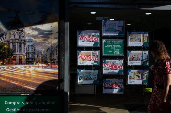 Inmobiliaria con anuncios de pisos y casas con algunos carteles de vendido. 
