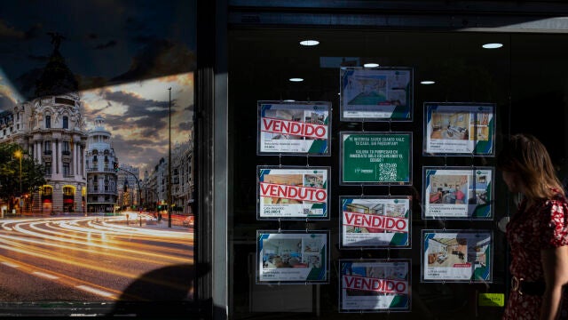 Inmobiliaria con anuncios de pisos y casas con algunos carteles de vendido. 