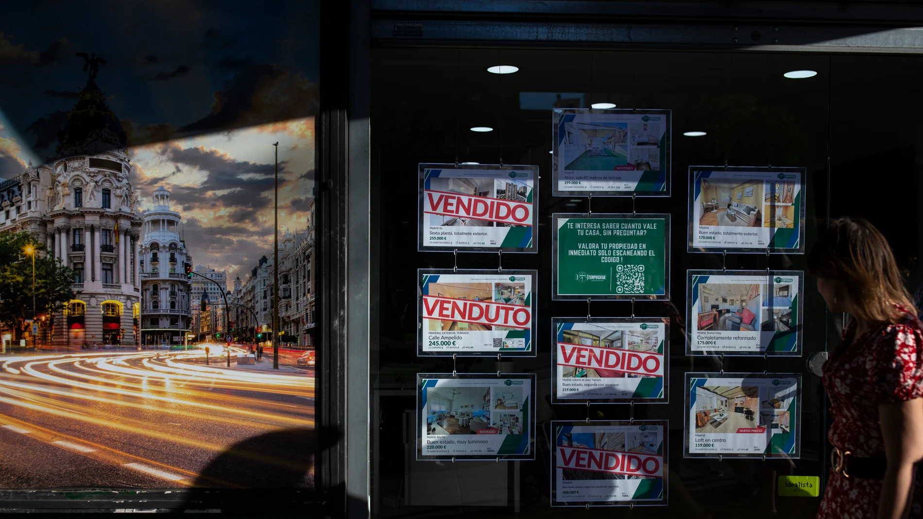 Inmobiliaria con anuncios de pisos y casas con algunos carteles de vendido.
