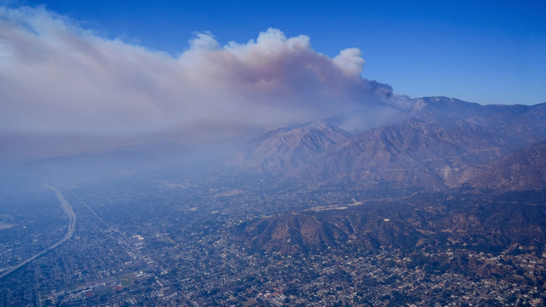 A plume of smoke from a wildfire forms over the city's basin Thursday, Jan. 9, 2025 in Los Angeles. (AP Photo/Mark J. Terrill)