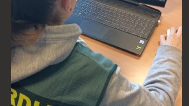 Un agente observa el ordenador del detenido que consultaba el semanario Al Naba del Estado Islámico