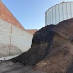  En la montaña de arroz inservible hay partes que se han quedado solidificadas y ahora necesitan romperlas con una máquina antes de que se las puedan llevar