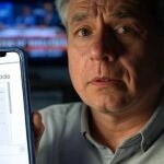 Un hombre muestra un correo phishing en su móvil (imagen generada con IA).