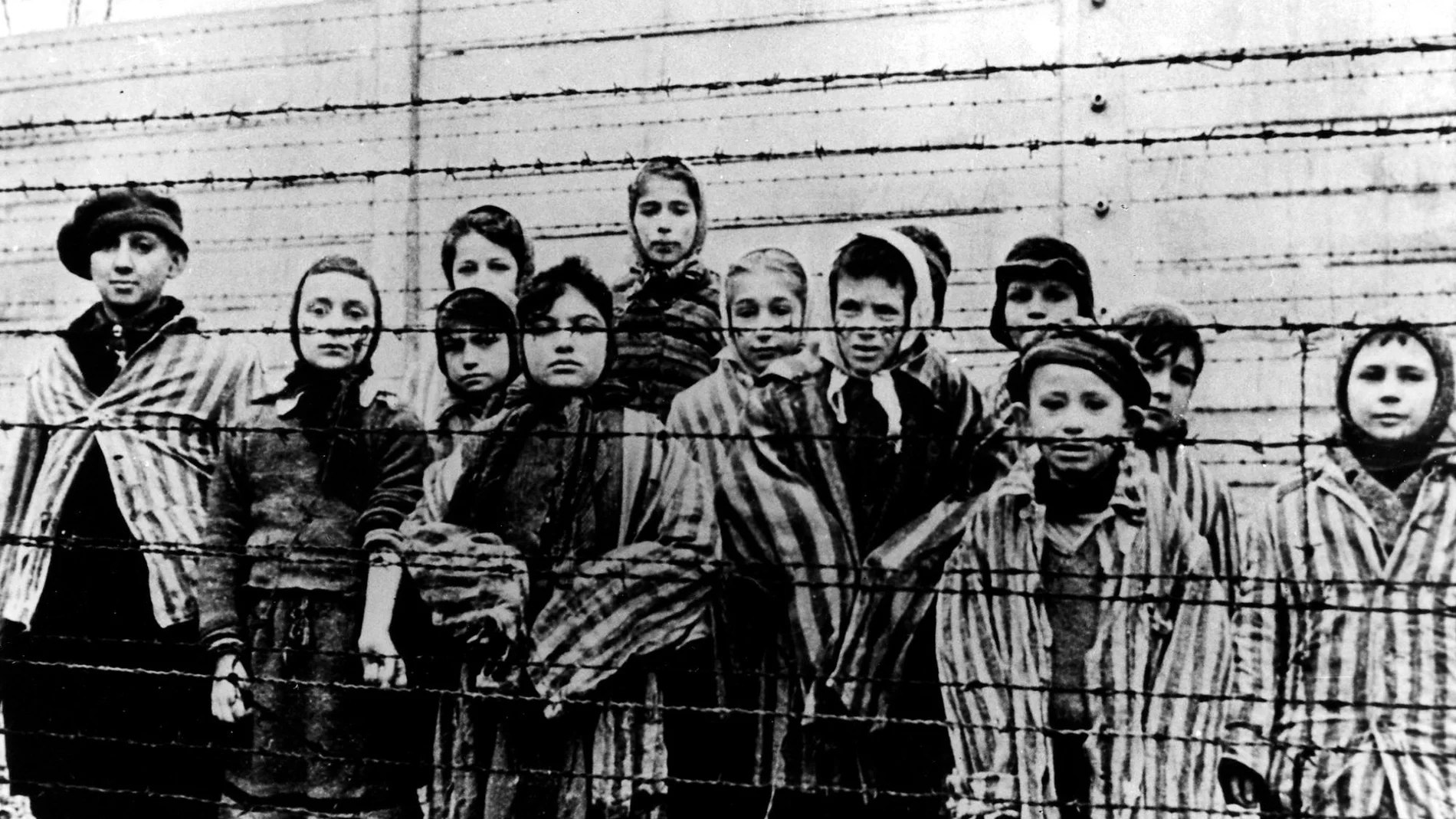 A picture taken just after the liberation by the Soviet army in January, 1945, shows a group of children wearing concentration camp uniforms behind barbed wire fencing in the Oswiecim (Auschwitz) nazi concentration camp.