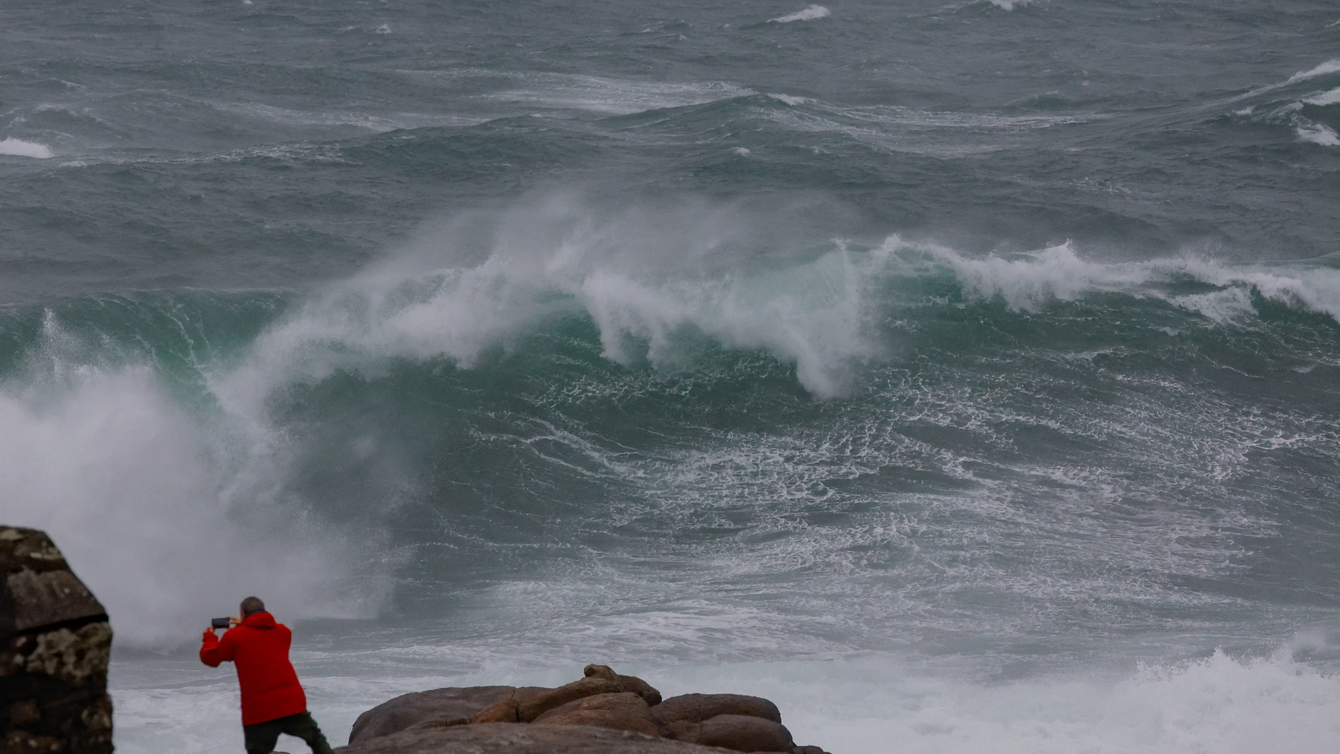 FOTODELDÍA MUXÍA (A CORUÑA), 26/01/2025.-Una persona en la costa de Muxía, A Coruña, este domingo. Un potente temporal asociado a la borrasca Herminia azotar con fuerza a la península, con lluvias muy intensas y generalizadas, viento con rachas huracanadas por encima de los 20 kilómetros por hora en algunos puntos y aviso rojo en Galicia, donde las olas pueden alcanzar 10 metros de altura. EFE/Lavandeira jr
