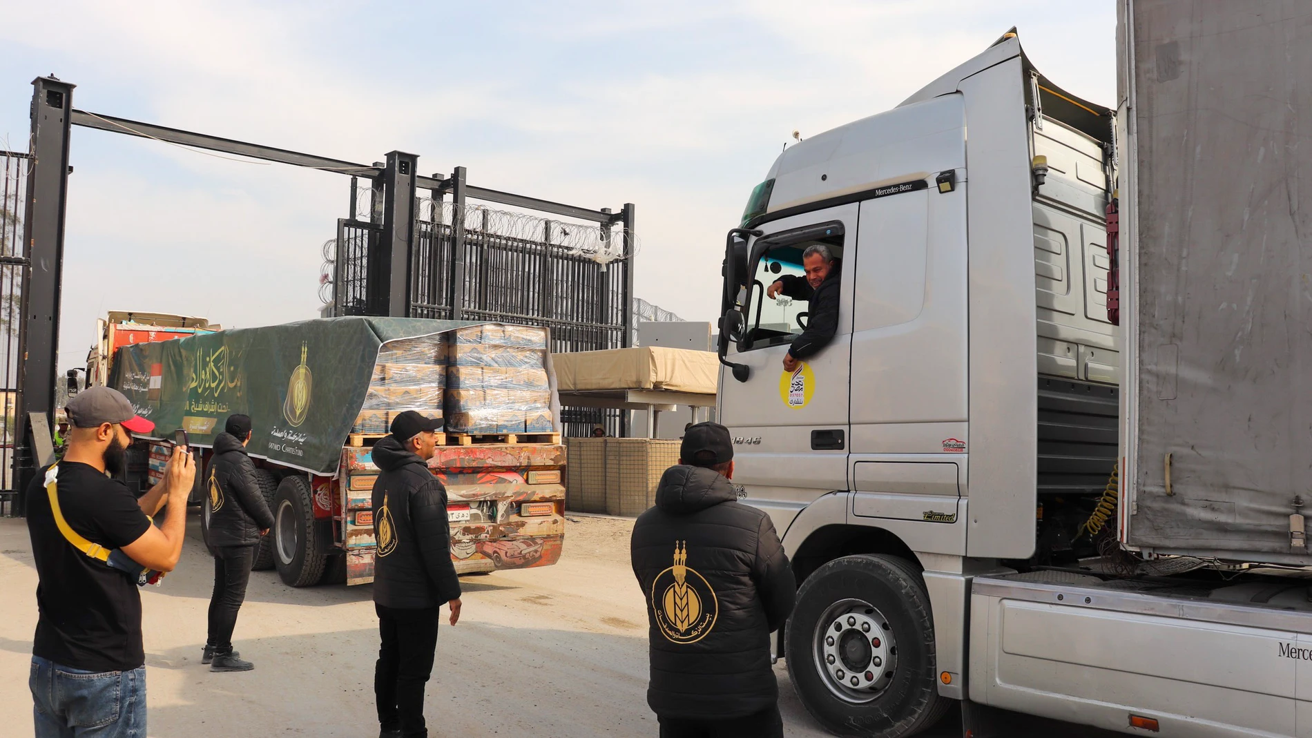 . RAFAH (EGIPTO), 28/01/2025.- Un conductor saluda a la prensa este martes a las puertas de la Franja de Gaza. Un total de 378 camiones cargados con ayuda humanitaria y otros 10 con combustible cruzaron este martes el paso fronterizo de Rafah, en el Sinaí egipcio, para transportar el cargamento a la Franja de Gaza, constató EFE sobre el terreno. EFE/Maria Morales