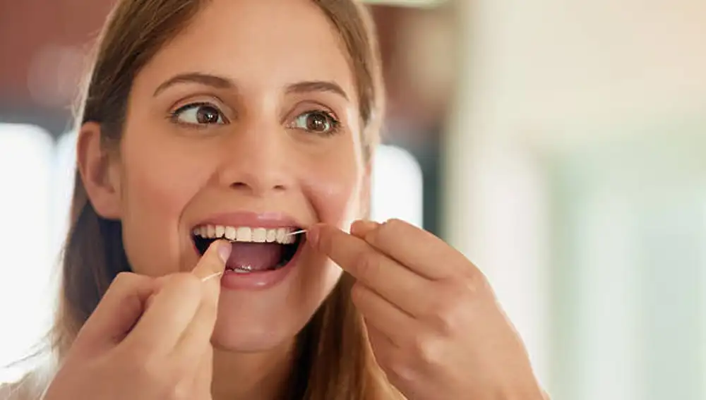 El hilo dental es crucial, ya que limpia aproximadamente el 40% de la superficie dental, mientras que el cepillado cubre el otro 60%