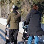 Dos personas pasan por un puente de Sevilla