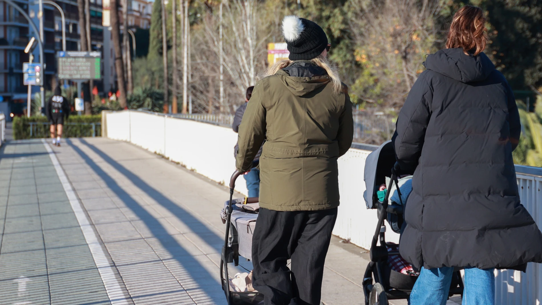 Dos personas pasan por un puente de Sevilla