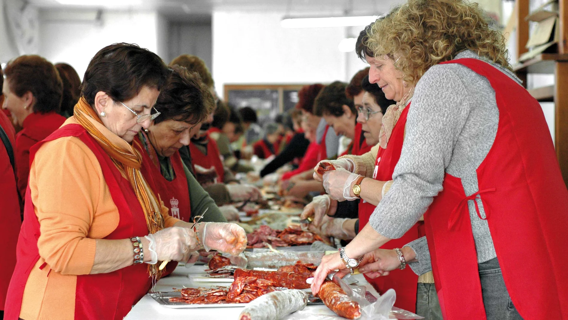 Vecinas de la localidad malagueña preparan productos derivados de la matanza del cerdo para repartirlos durante la festividad