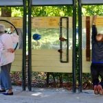 personas mayores haciendo ejercicios de gimnasia en aparatos en un parque
