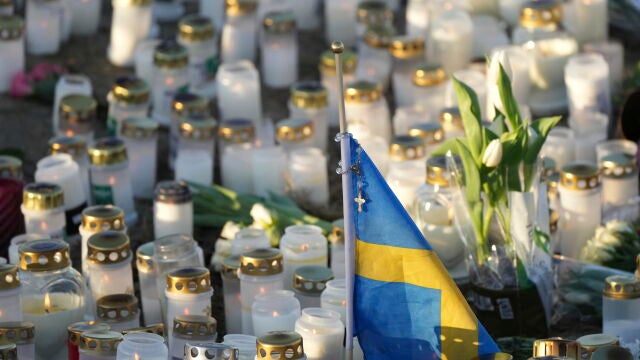 La bandera sueca entre las flores y velas de un memorial por las víctimas del tiroteo masivo en Örebro