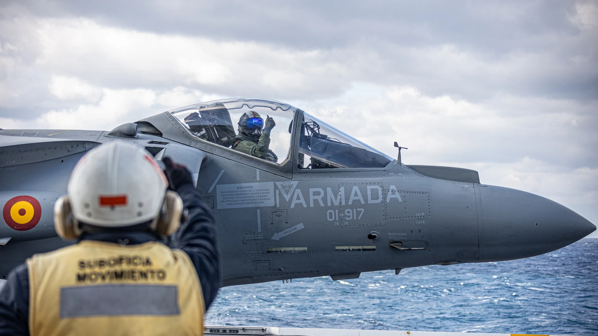 Un operario da indicaciones al piloto de un Harrier justo antes de su despegue desde el LHD Juan Carlos I