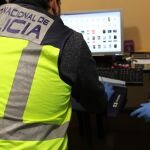 Agentes de la Policía Nacional inspeccionando un ordenador