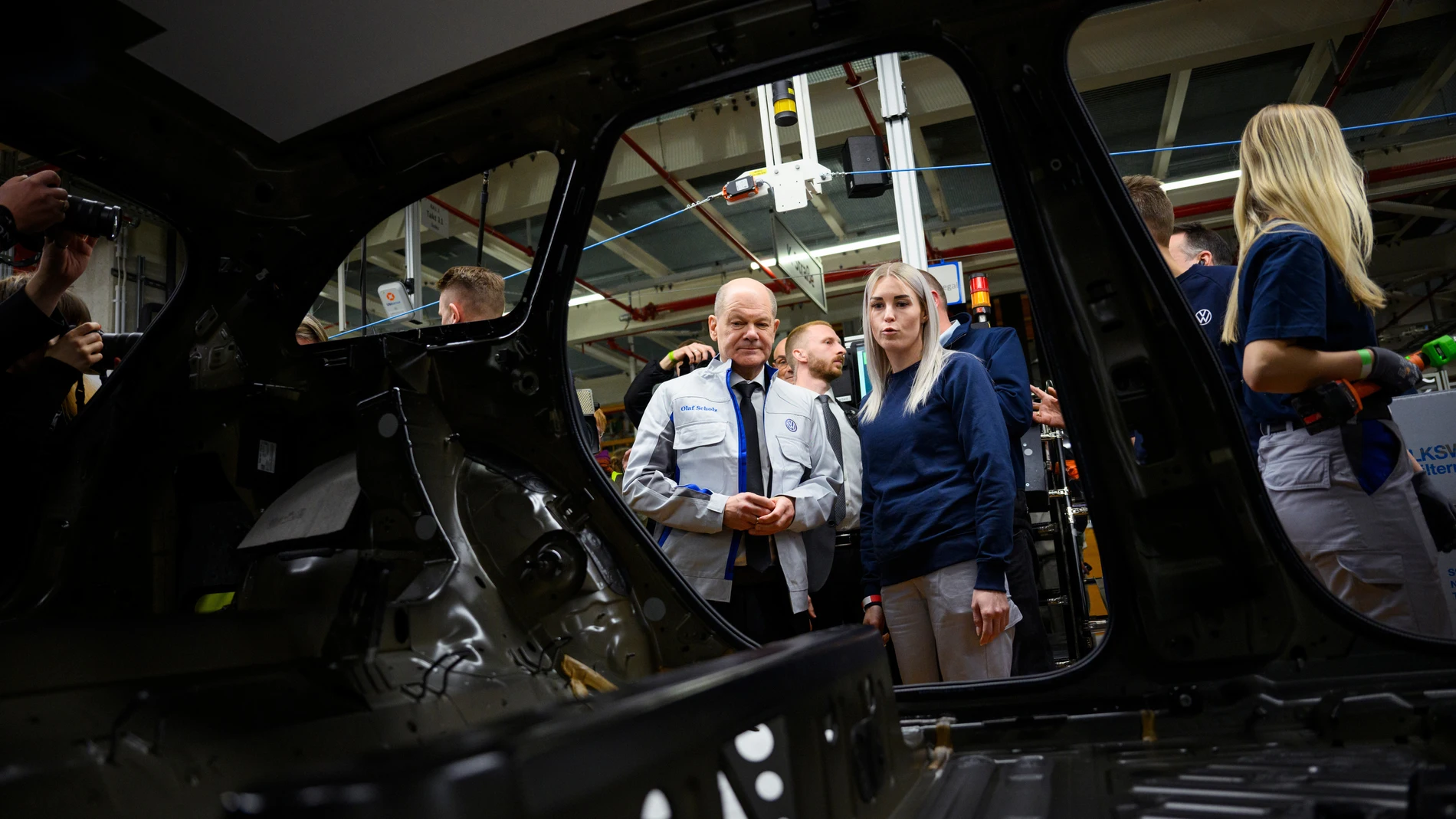 EMDEN (Germany), 18/02/2025.- German Chancellor Olaf Scholz talks to a Volkswagen employee alongside an assembly line for the VW electric car ID.7 during his visit of the Volkswagen factory in Emden, Germany, 18 February 2025. Volkswagen Emden mainly produces electric vehicles such as the ID.4 and ID.7 on an area of 4.300.000 square metres with more than 8000 employees, according to information from the company. (Alemania) EFE/EPA/GREGOR FISCHER