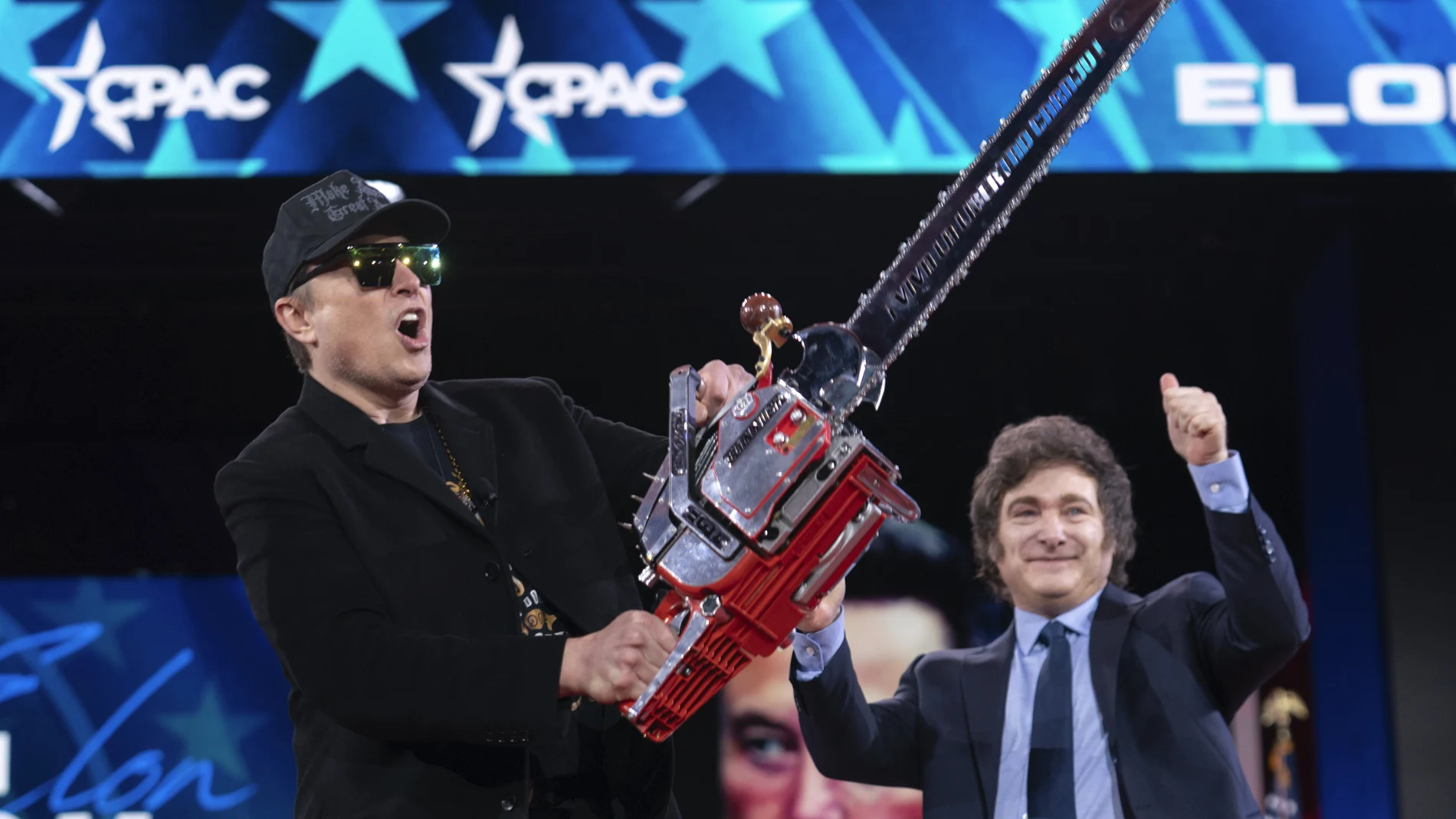 Elon Musk, left, receives a chainsaw from Argentina's President Javier Milei as they arrive speaks at the Conservative Political Action Conference, CPAC, at the Gaylord National Resort & Convention Center, Thursday, Feb. 20, 2025, in Oxon Hill, Md.