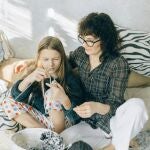 Madre enseñando a su hija a tejer