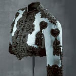Bolero en terciopelo de seda azul con aplicaciones de terciopelo negro. 