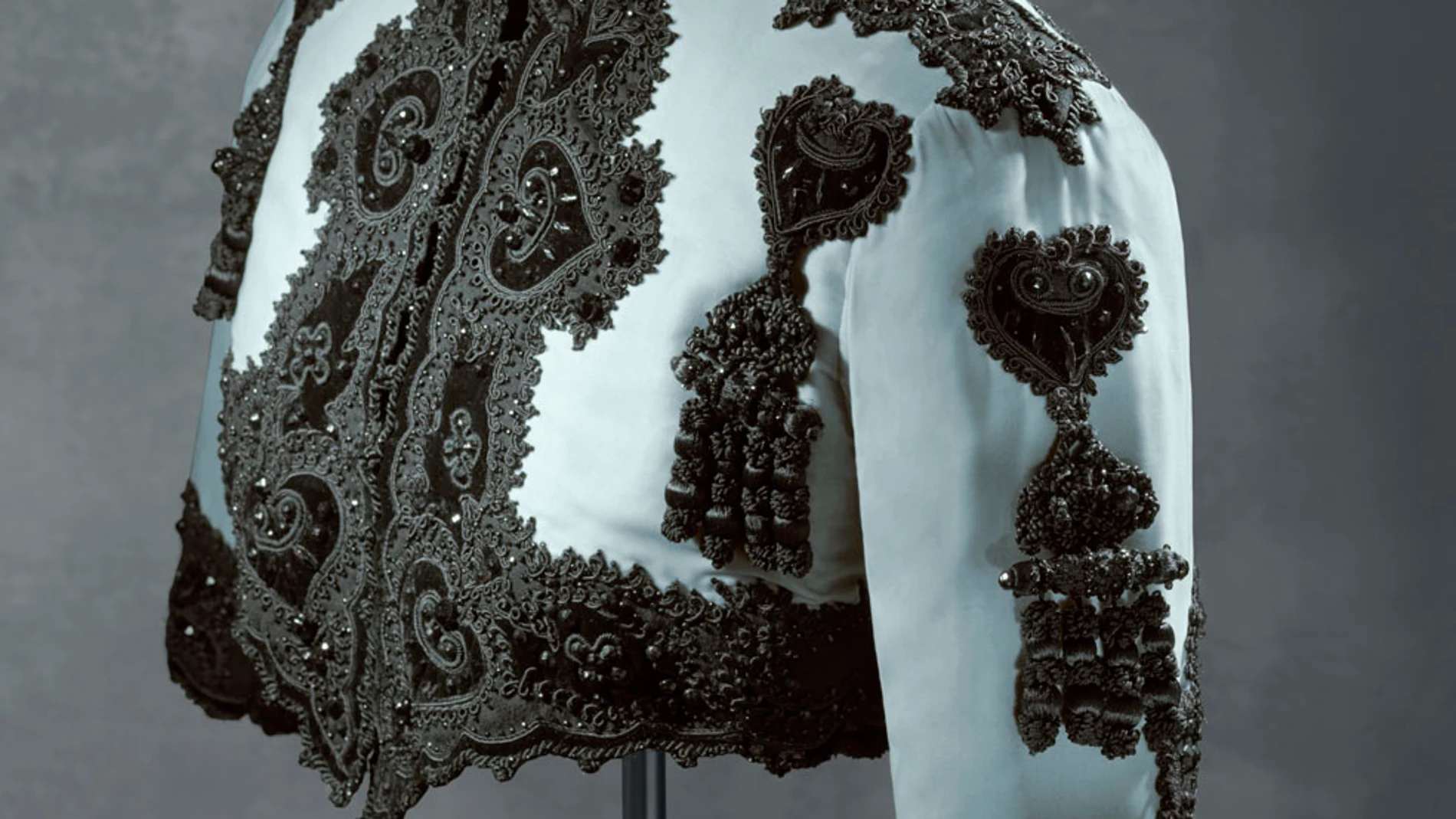 Bolero en terciopelo de seda azul con aplicaciones de terciopelo negro.