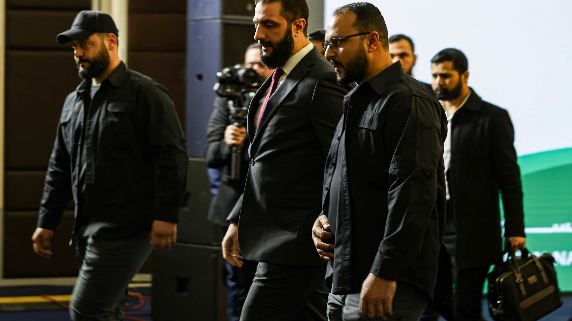 Syria's interim president Ahmad al-Sharaa, center, arrives to speak at Syria's national dialogue conference at the Dama Rose hotel in Damascus, Syria, Tuesday Feb. 25, 2025.(AP Photo/Omar Albam)