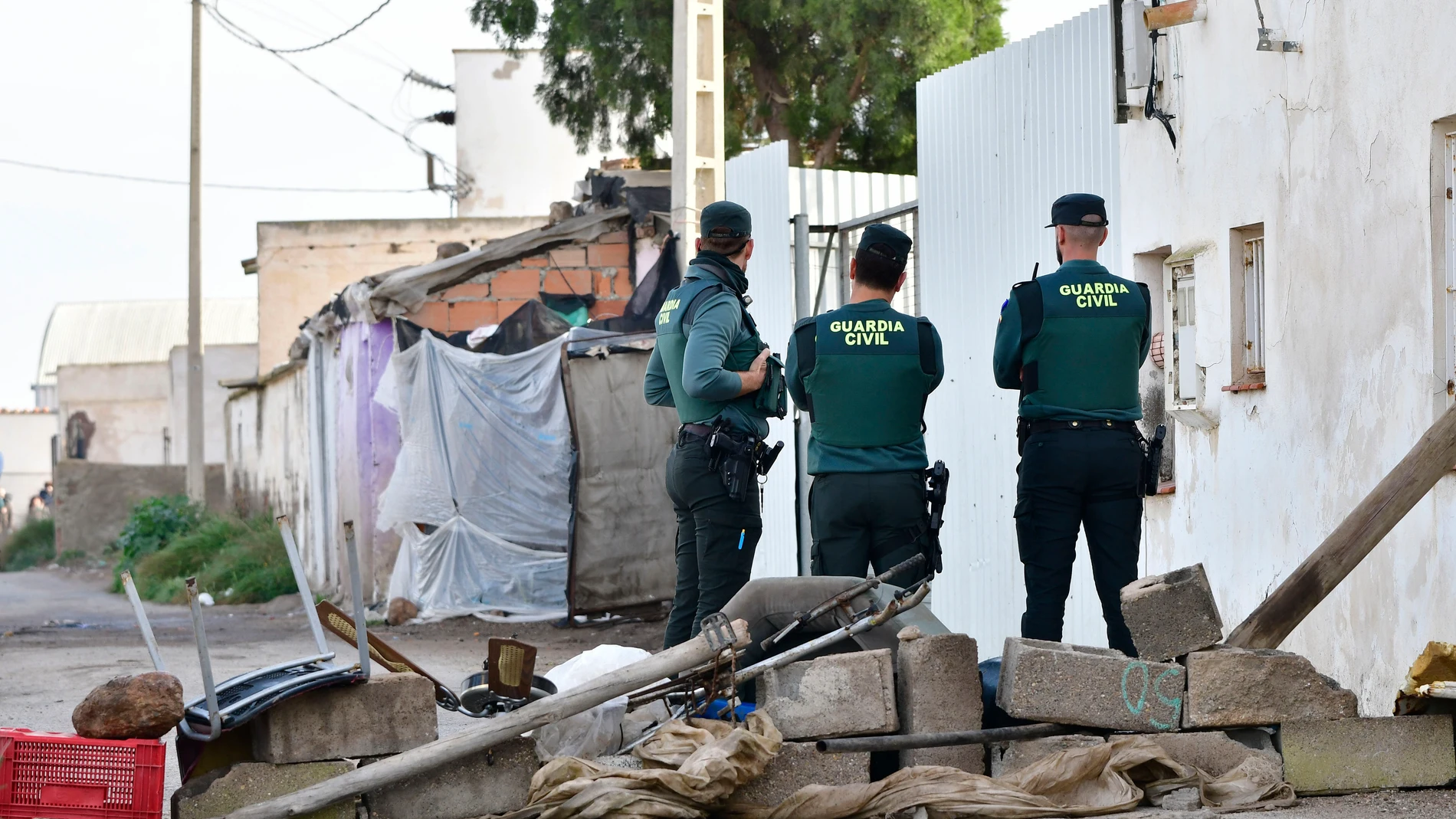 NÍJAR (ALMERÍA), 25/02/2025.- Varios miembros de la Guardia Civil entran en el asentamiento 'Cortijo El Uno', poco antes de ejecutarse el desalojo del recinto por orden judicial. Unos sesenta inmigrantes, entre ellos seis familias con nueve niños, serán desalojados de un poblado chabolista en Níjar (Almería), un desalojo ordenado por un juzgado tras la demanda del propietario de los terrenos. EFE/Carlos Barba