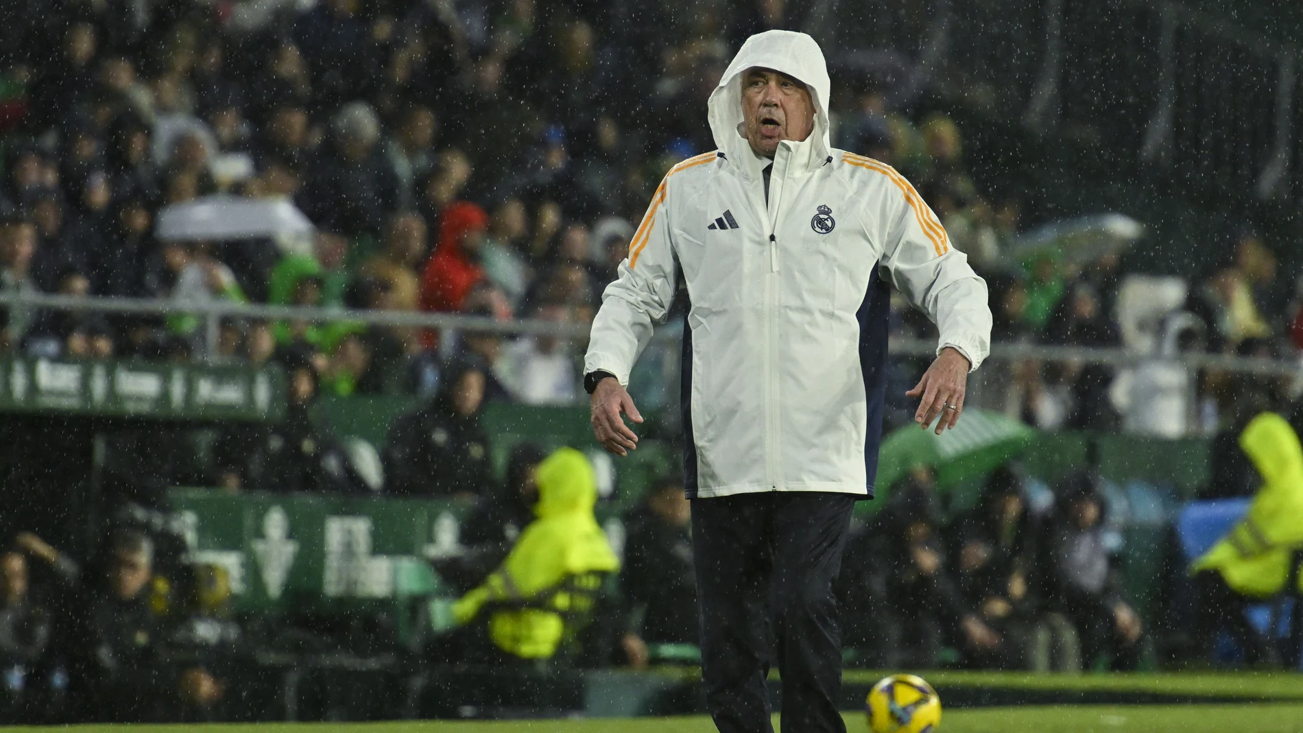 Ancelotti, protegido de la lluvia durante el partido ante el Betis
