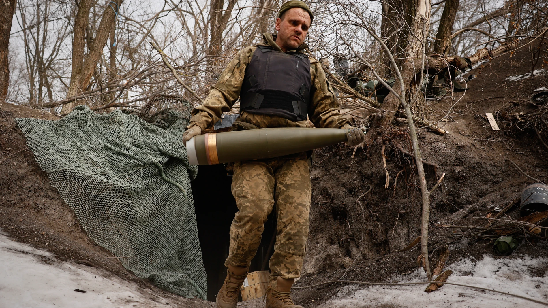 An Ukrainian serviceman carries a shell to fire a M777 howitzer towards Russian positions at the frontline near Donetsk, Ukraine, Sunday, March, 2, 2025. (AP Photo/Roman Chop)