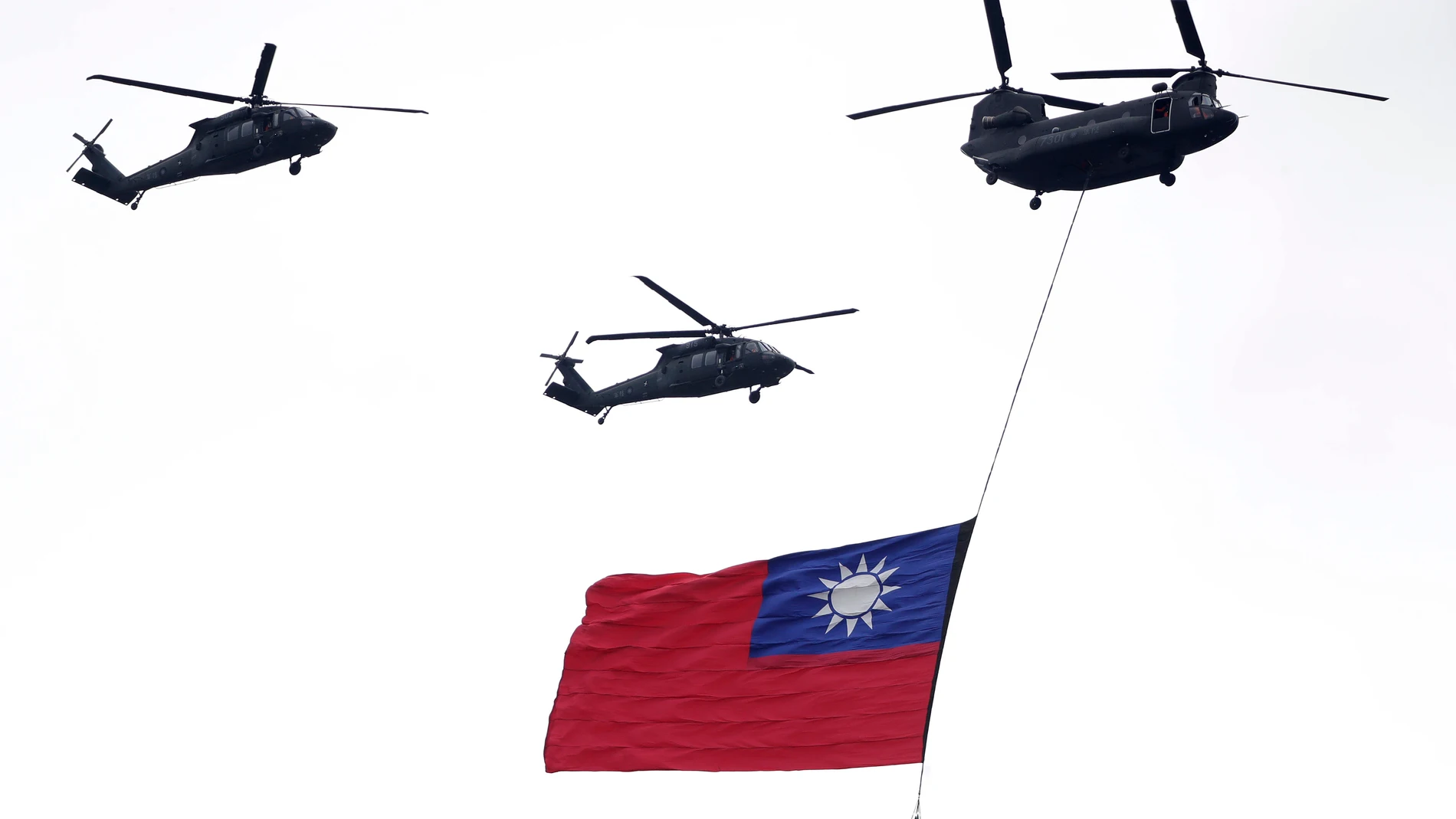FILE - Helicopters fly over with Taiwan national flag during an inauguration celebration of Taiwan's President Lai Ching-te in Taipei, Taiwan, on May 20, 2024. (AP Photo/Chiang Ying-ying, File)