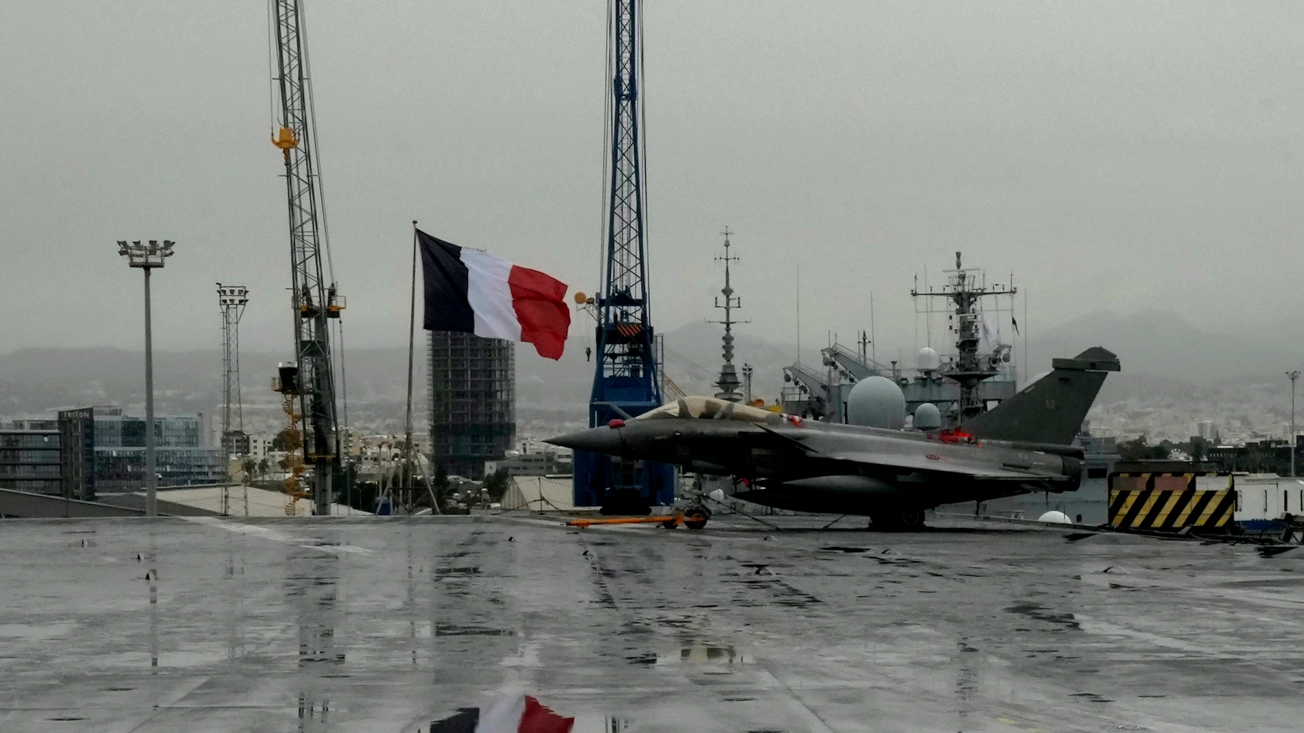 Un caza Rafale junto a una bandera francesa, en el portaaviones de propulsión nuclear francés Charles de Gaulle, en el puerto de Limassol, Chipre