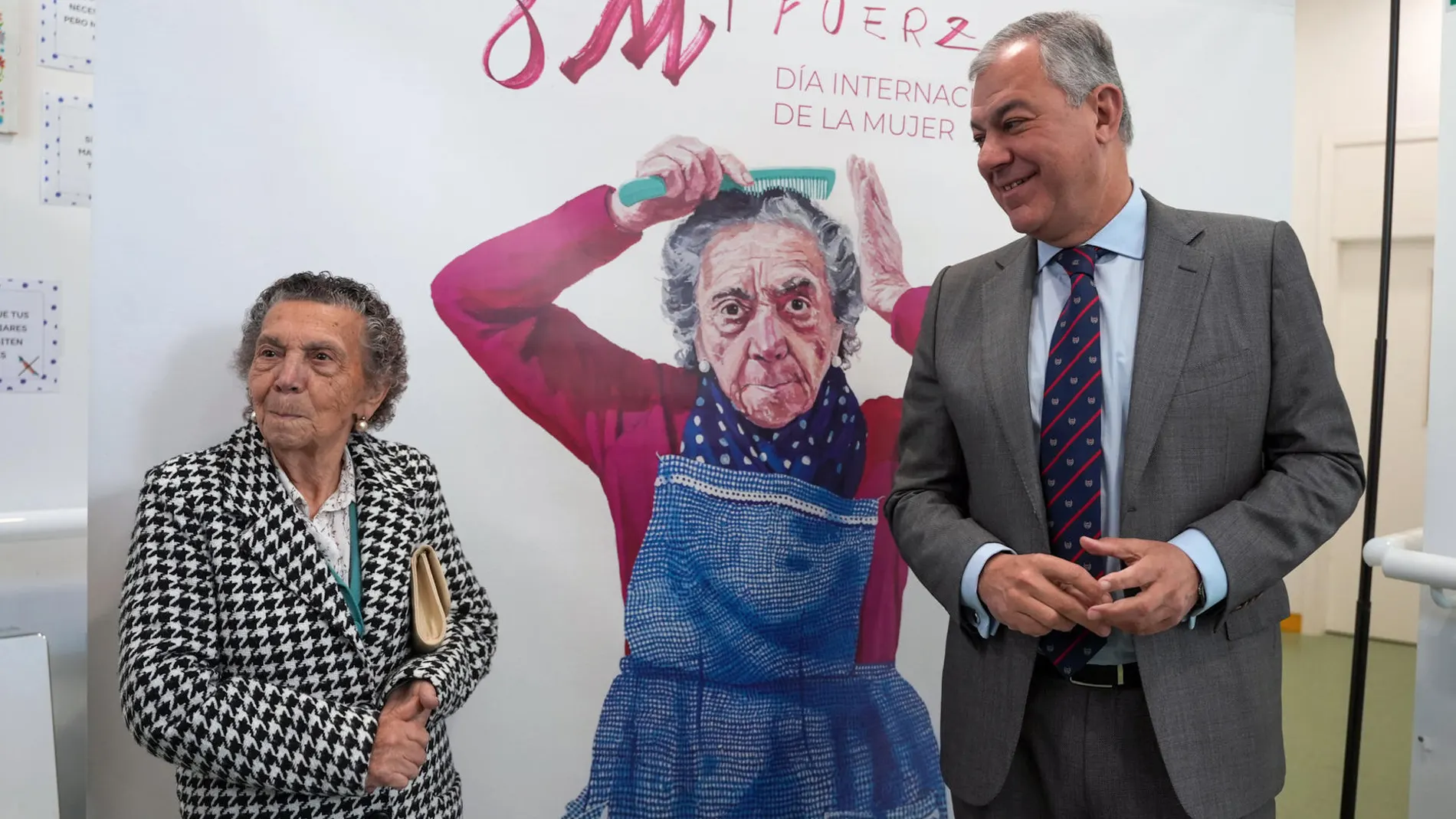Una mujer de 86 años con delantal, cartel de Sevilla para el 8M