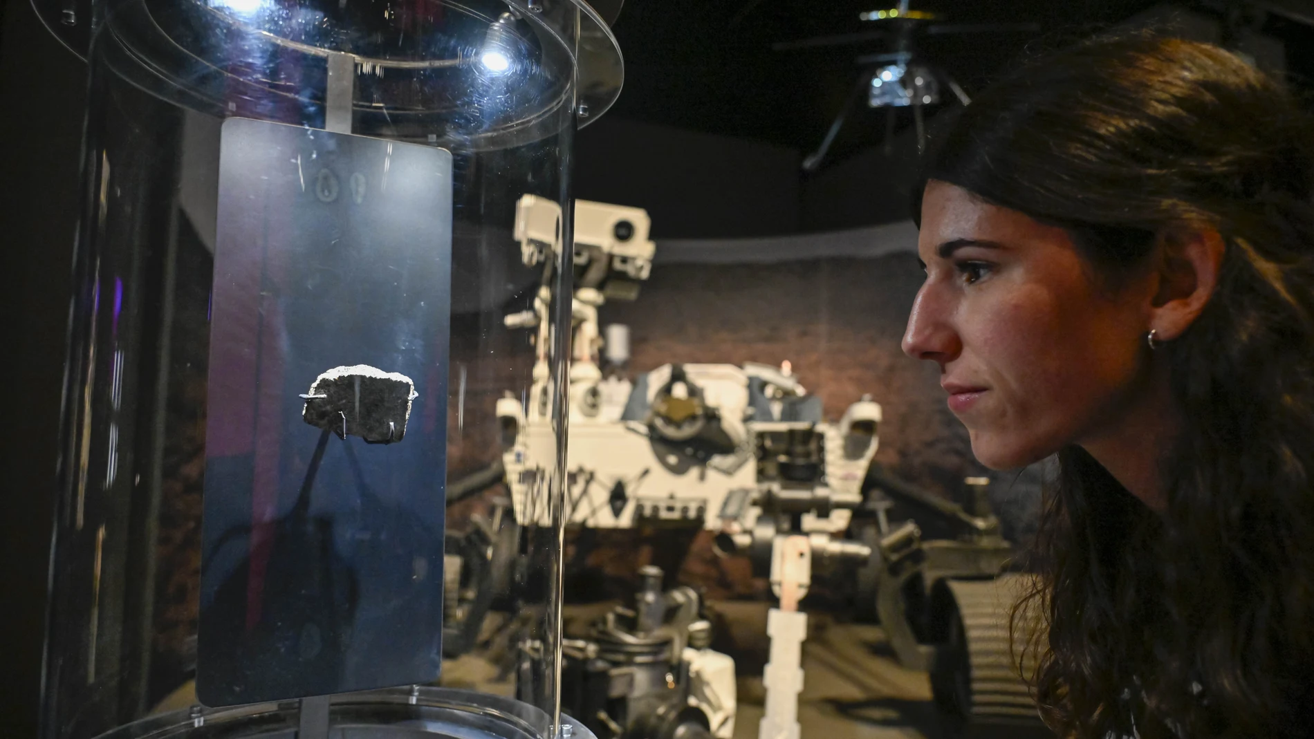 Una visitante de la muestra contempla el fragmento de un meteorito procedente de Marte