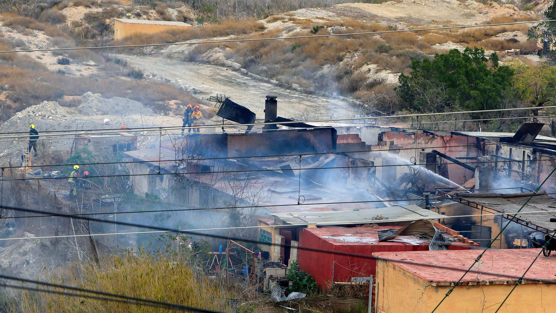 GRAFCVA6080. ALICANTE, 06/03/2025.- Varios bomberos realizan labores de extinción en la empresa pirotécnica de la partida de Fontcalent, en el término de Alicante, donde una persona esta desparecida y cuatro heridas de diversa gravedad a causa de una explosión y posterior incendio de las instalaciones. EFE/Morell