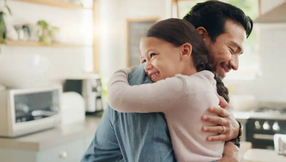 Una nila abraza a su padre