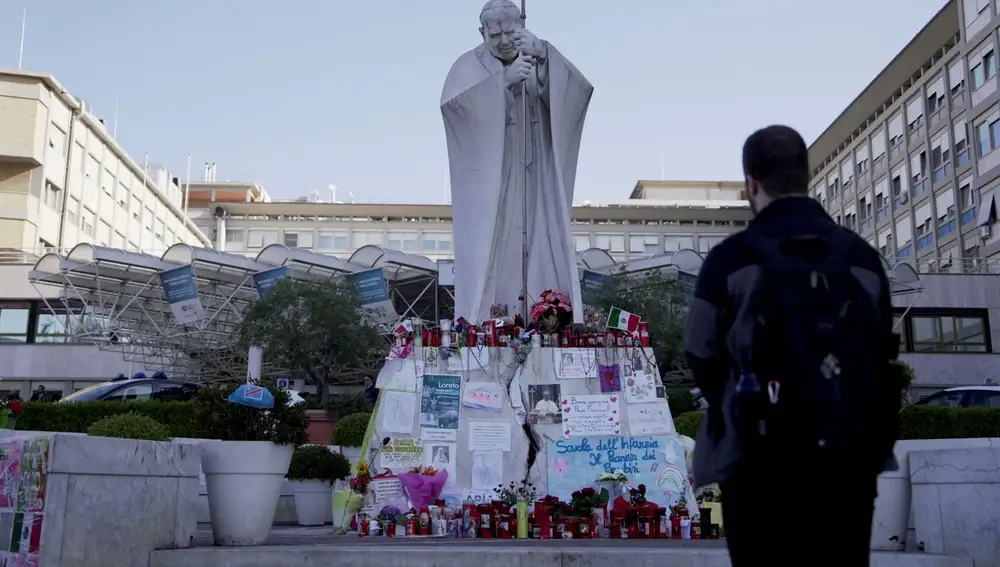 Una persona frente al altar improvisado a las puertas del hospital Gamelli de Roma