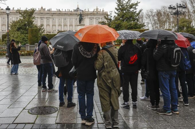 Un grupo de turistas se protegen de la lluvia con sus paraguas en el centro de Madrid. Un grupo de turistas se protegen de la lluvia con sus paraguas en el centro de Madrid.